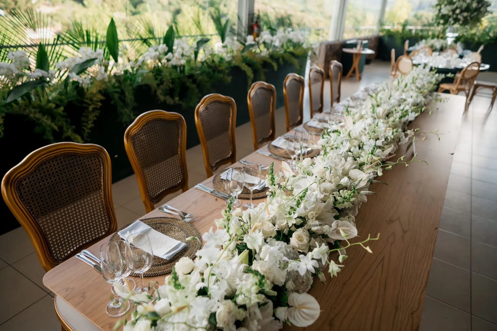Long wedding table with white floral arrangement — 20-person wedding budget breakdown