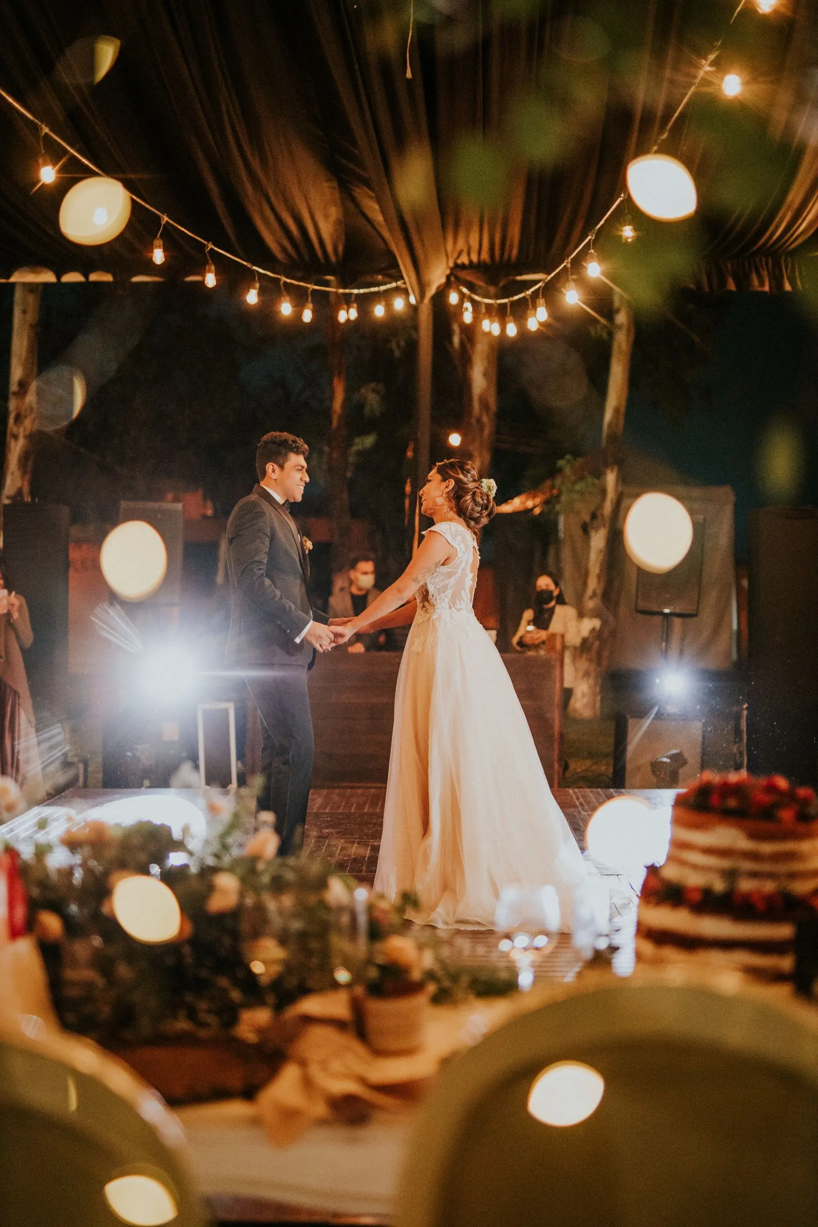 Newlywed couple during an evening wedding celebration with string lights — 30-guest wedding reception under $3,000