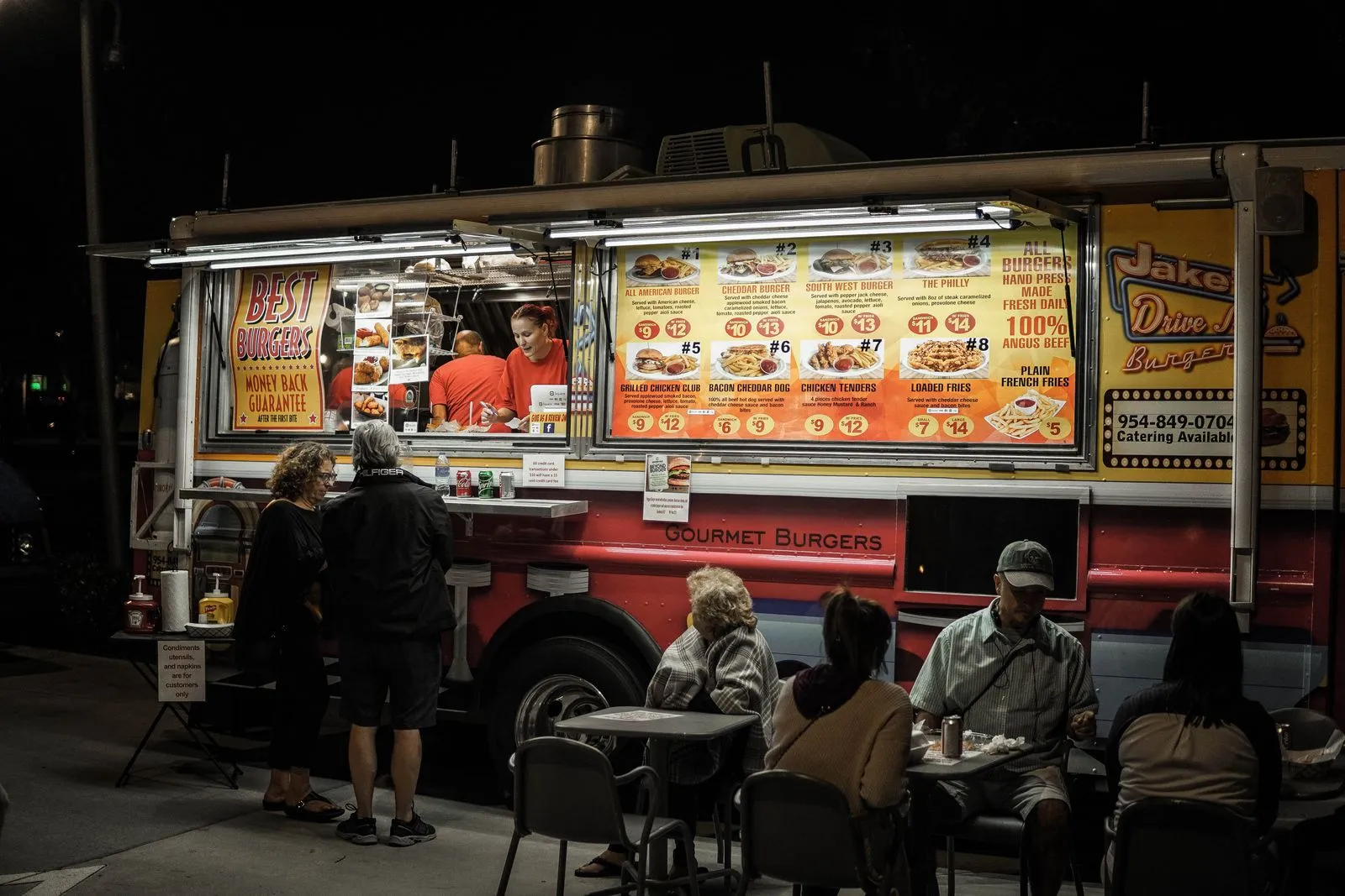 Guests sitting near a food truck at night at a backyard wedding — 50-person backyard wedding budget with food