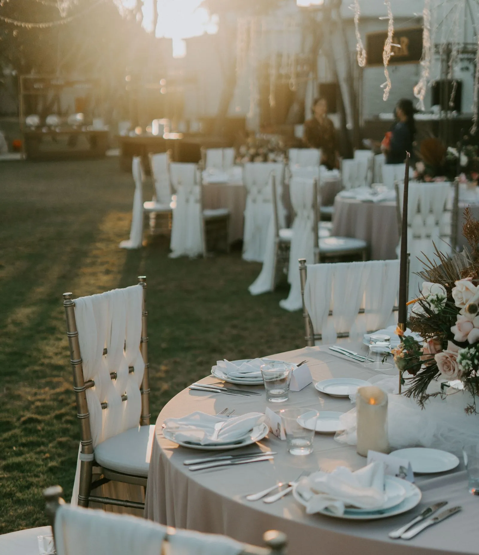 Outdoor wedding tables and chairs set up at sunset — 50-person backyard wedding budget with food